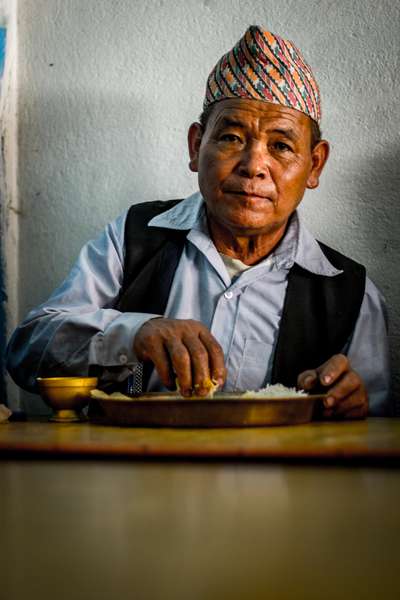 A man lunches on dhal bhat, Nepal